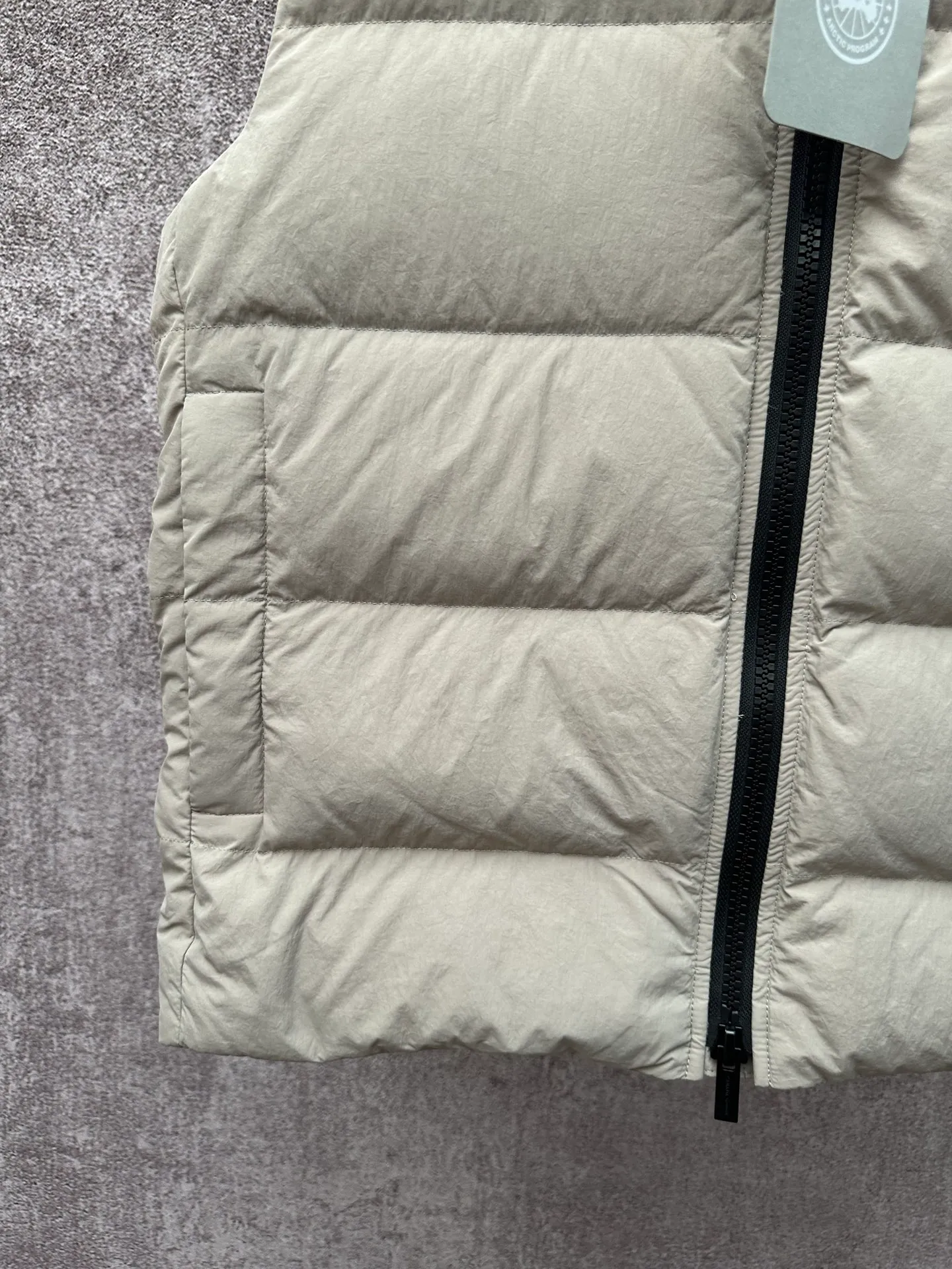 P720 Canada Goose Badge Down Vest Fabric selection: The use of high-quality protective nylon fabric not only enhances the wear resistance of the surface, but also takes into account wind resistance, ensuring excellent performance in various harsh weather conditions.  90 national standard high-quality white duck down: selected high-loft down, weighing 160g, light and warm, with excellent temperature locking performance and good resilience.  Three-dimensional quilting process: Precision thread reinforcement to prevent velvet drilling and ensure that the fluffy and resilient elasticity lasts as new.  Details: The ribbon is woven with polyester as the base, and the brand letters are decorated on the ribbon through high-precision computer embroidery. The edges of the pattern are clear, the stitches are fine and even, and multiple layers of embroidery thread are stacked to enhance the three-dimensional effect. Accessories: One-to-one customized logo, one-to-one customized zipper puller, one-to-one customized three-label SIZE: S M L XL